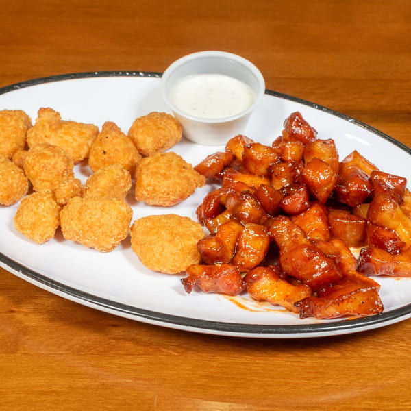 A white platter with crispy fried cheese curds, barbecue chicken bites, and a side of ranch dressing.